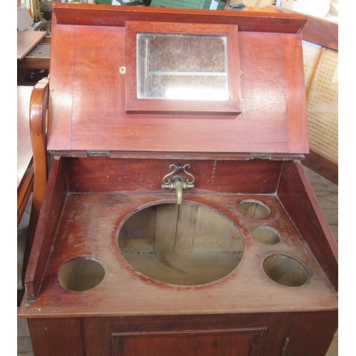 12 - A Victorian mahogany wash stand/desk, with sloping hinged lid, fitted with a cupboard