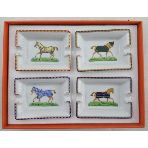 191 - A boxed set of four Hermes porcelain ashtrays, printed with racehorses, together with another boxed ... 