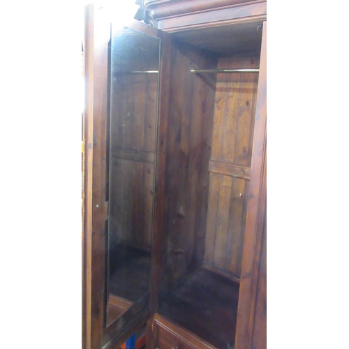 9 - A stained pine three door wardrobe, with bezel drawers, width 60ins, height 79ins, depth 21ins