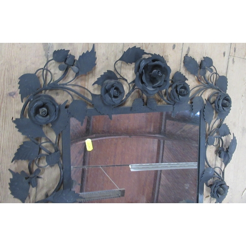 521 - A wall mirror, the black metal frame decorated with roses and leaves