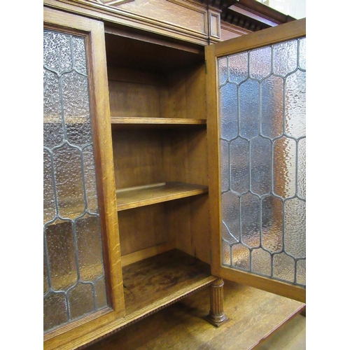 112 - A large 19th century oak cabinet the upper section having glazed lead doors opening to reveal shelve... 