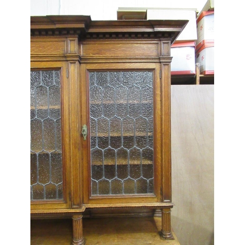 112 - A large 19th century oak cabinet the upper section having glazed lead doors opening to reveal shelve... 