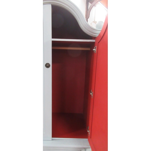 15 - A painted arched top wardrobe, fitted with a pair of cupboard doors over drawers to the base, on cab... 