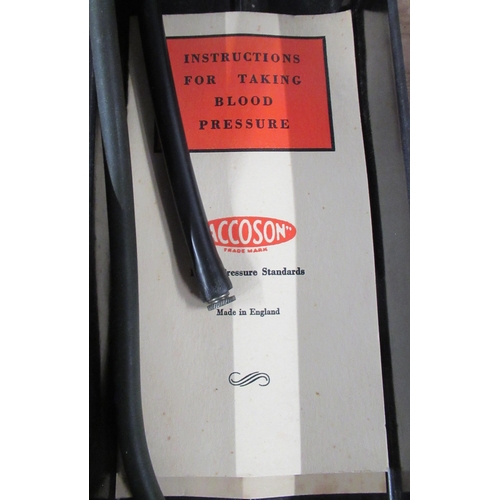 185 - An Accoson blood pressure gauge, with cuff, in bakelite box