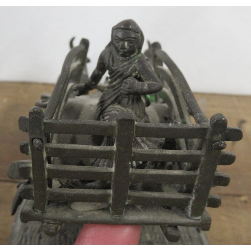 196 - An Eastern metal model, of a girl seated in a cart pulled by two oxen