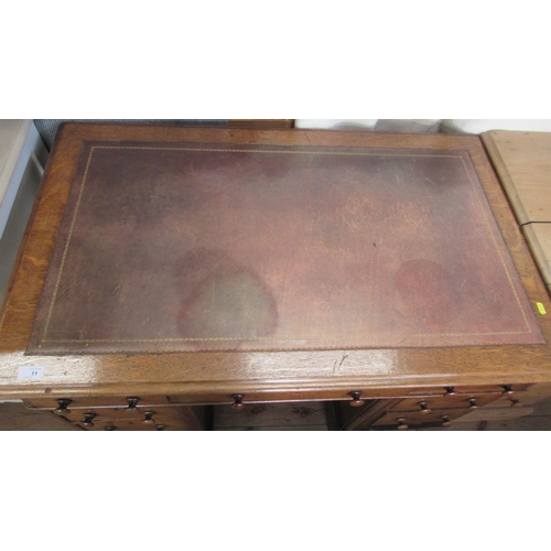 11 - A 19th century oak pedestal desk, with inset leather writing surface and an arrangement of nine draw... 