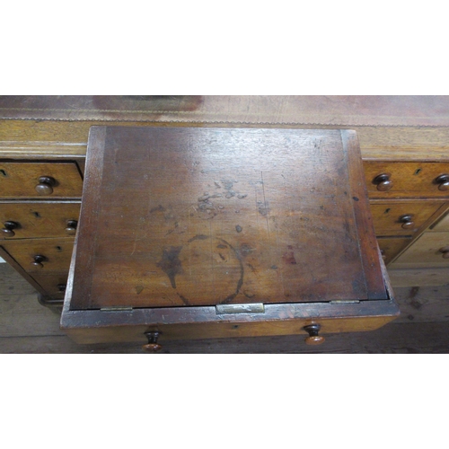 11 - A 19th century oak pedestal desk, with inset leather writing surface and an arrangement of nine draw... 