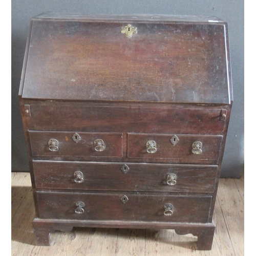 24 - An Antique oak bureau, the fall flap revealing a fitted interior of a well, drawers and pigeon holes... 