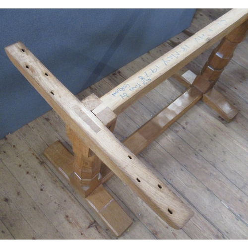 54 - A 1970's Robert Thompson Mouseman oak refectory dining table, with adze top, raised on end supports ... 