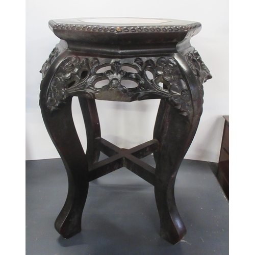 8 - An Eastern ebonised plant stand, with marble inset into the octagonal top, with pierced and carved d... 