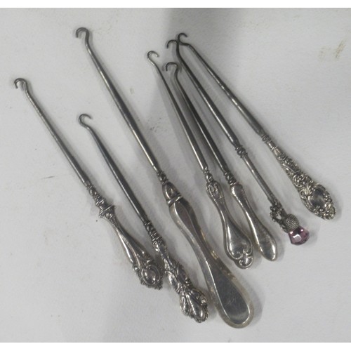 A collection of button hooks, some with silver handles