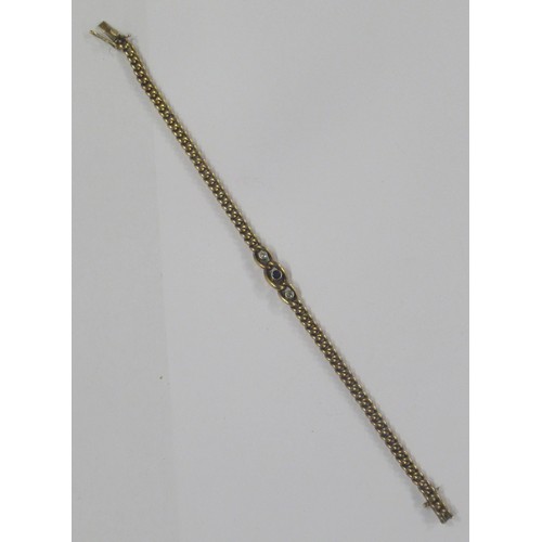 425 - A 14ct gold curb link bracelet, rub over set with a round cut sapphire flanked by two old cut diamon... 