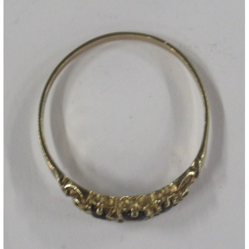 427 - A 9ct graduated three stone garnet set ring, cast scroll shoulders, hallmark indistinct