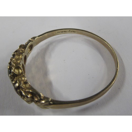 427 - A 9ct graduated three stone garnet set ring, cast scroll shoulders, hallmark indistinct