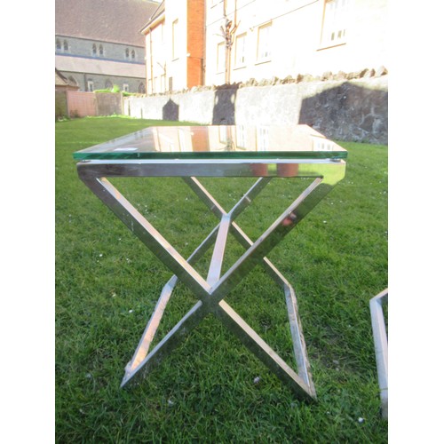 26 - A pair of chrome and glass topped coffee tables, on cross bases, width 18ins, height 22ins