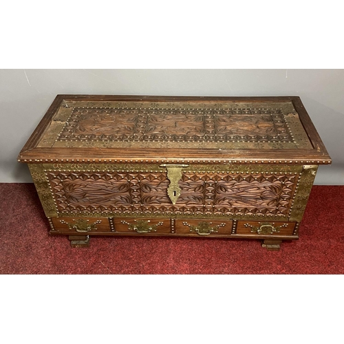 199 - A nicely carved rosewood trunk of Oriental origin having brass decoration and hardware, with interna... 