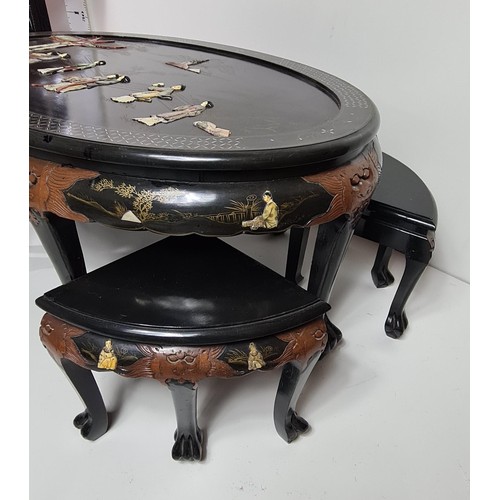 75 - A fine Oriental black lacquered coffee table with four stools under. Hand decorated with C19th scene... 