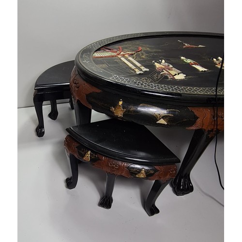 75 - A fine Oriental black lacquered coffee table with four stools under. Hand decorated with C19th scene... 