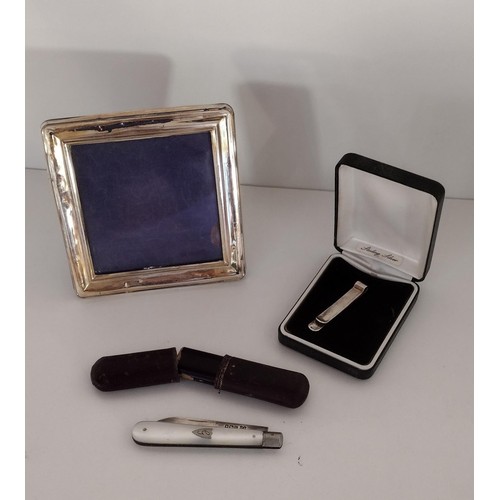 116 - Selection of silver items comprising a penknife, photo frame and a tie clip. Shipping group (A), opt... 