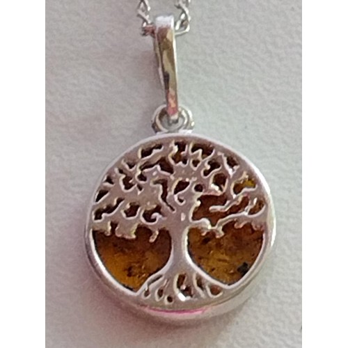 58 - Silver and amber tree of life pendant on chain. Shipping Group (A).