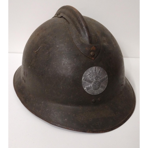 171 - WWI French Adrian helmet featuring artillery insignia with liner and strap. Shipping Group (A).