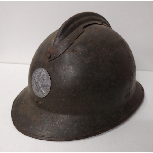 171 - WWI French Adrian helmet featuring artillery insignia with liner and strap. Shipping Group (A).