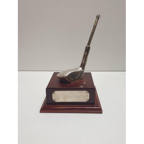 71 - White metal golfing trophy having propelling pencil and raised on wooded mount. Shipping Group (A).