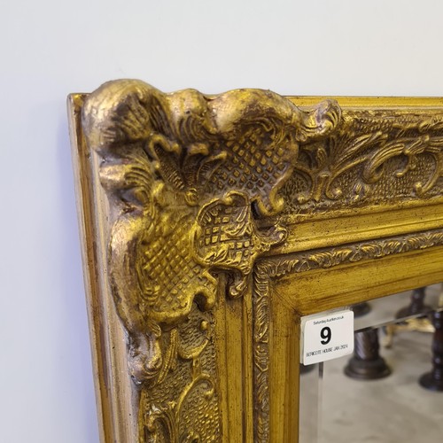 9 - A tall gilt framed and bevelled edge mirror of French style measuring 148 (h) x 85 (w) cm.