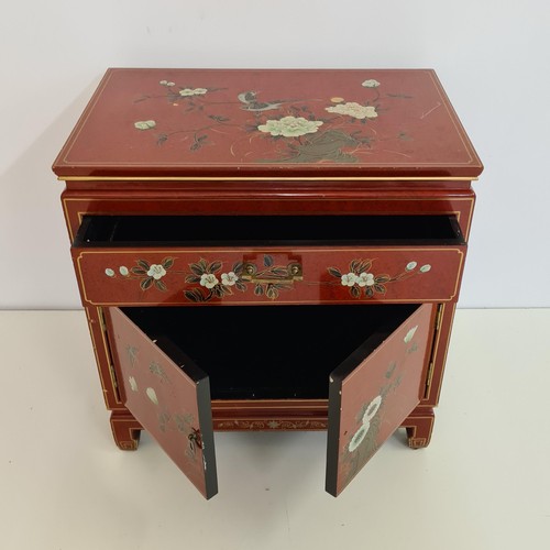 24 - An Oriental red lacquered cabinet measuring  62 (h) x 61 (w) x 41 (d).