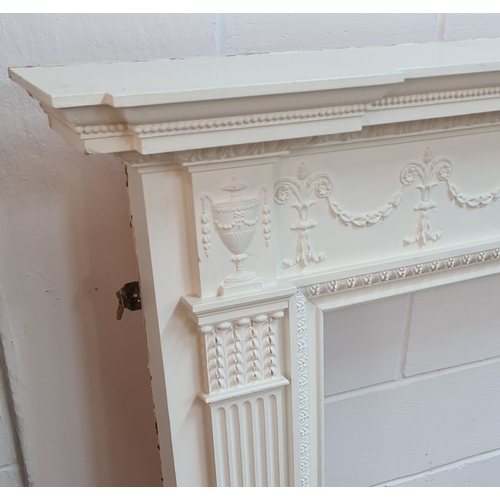 199 - An antique white painted wooden fire surround. 128 (h) x 169 (w) 19 (d).