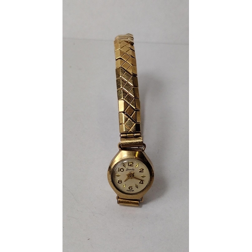 288 - 9ct gold ladies wrist watch with gold plated flexi strap. a/f. Shipping Group (A).