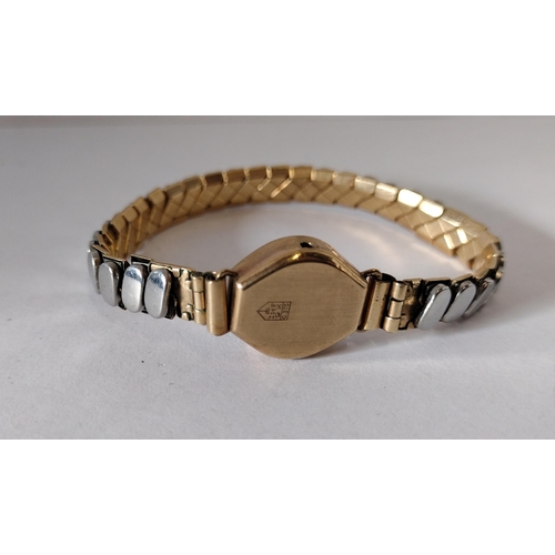 288 - 9ct gold ladies wrist watch with gold plated flexi strap. a/f. Shipping Group (A).