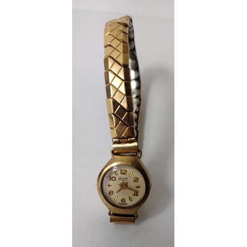 288 - 9ct gold ladies wrist watch with gold plated flexi strap. a/f. Shipping Group (A).