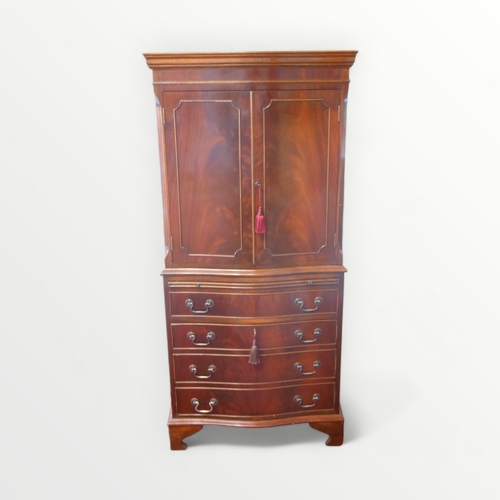 253 - Reproduction mahogany finished serpentine fronted 'drinks' cupboard having a 'prep slide' over a sin... 