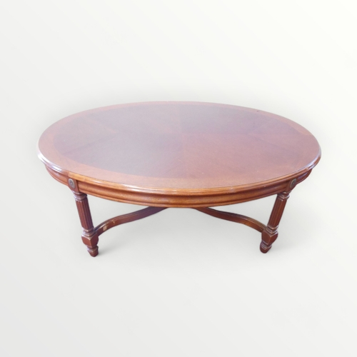 259 - Mahogany finished oval topped coffee table on four part reeded legs united by a fancy 'X' shaped str... 