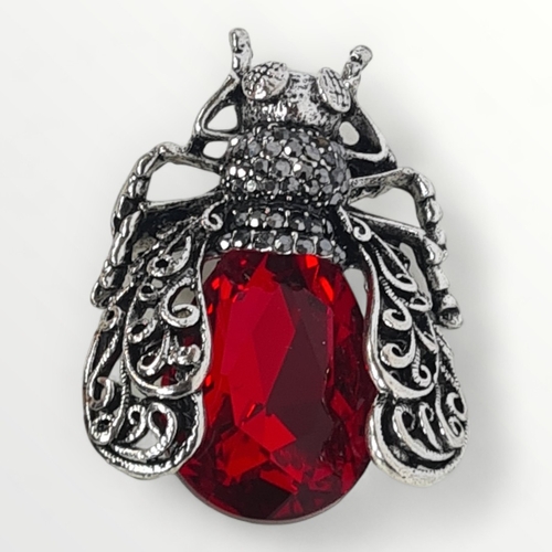 6 - A large silver and red coloured stone set bug brooch, approx 4cm. Shipping group (A).