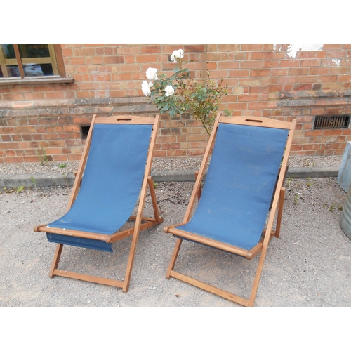 338 - A pair of teak framed folding deck chairs.