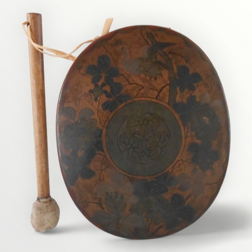 111 - Floral decorated metal gong and a beater. Shipping group (A).