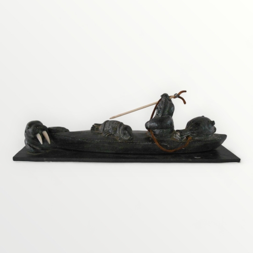 112 - Hand carved 'Inuit' stone sculpture of a hunting fisherman in his kayak. 33cm long. Shipping group (... 