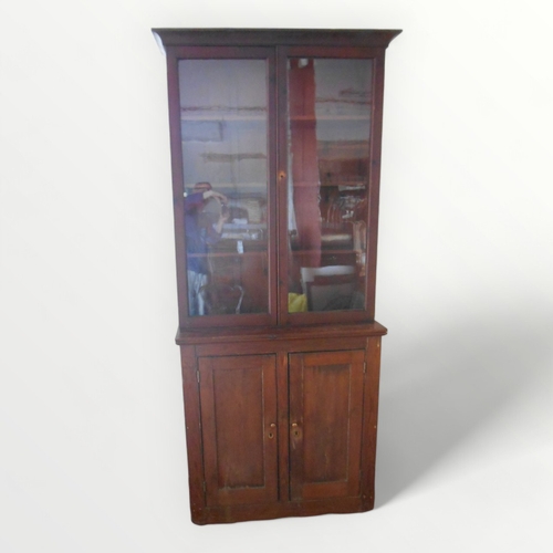 124 - 19th century stained pine bookcase having glazed upper section on a deeper two door cupboard base. 2... 