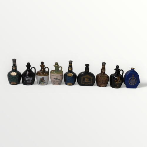 125 - Nine collectable pottery whisky decanters.