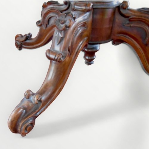 278 - Victorian walnut loo table having an oval top on a baluster column and four fancy carved legs with s... 