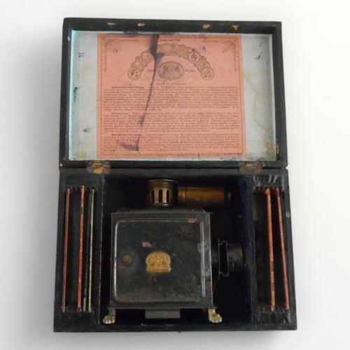 296 - Antique boxed German made 'Magic Lantern' of small proportions retaining some original slides, it st... 