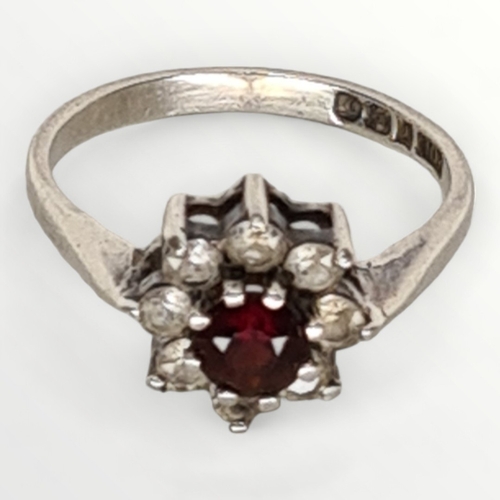 37 - Sterling silver, red stone and Cubic Zirconia set ring, size P. Shipping group (A).