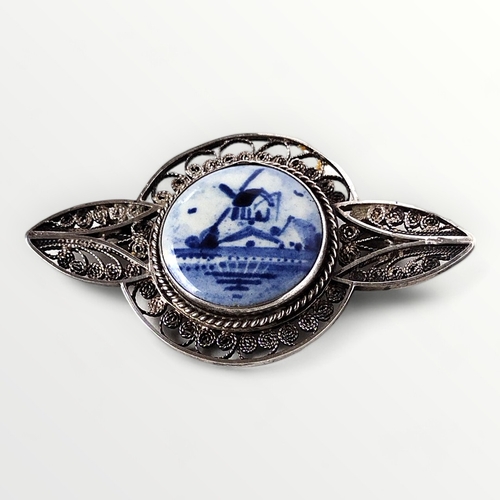 45 - Silver filigree brooch having a blue and white delft centre featuring a Dutch scene. 6cm across. Shi... 