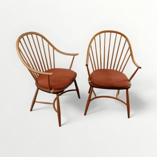 147 - A pair of Ercol stick back elm seated arm chairs, the plain legs united with a crinoline stretcher. ... 