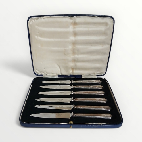 2 - Cased set of six silver handled butter knives. Sheffield hallmark, maker CHB. Shipping group (A).