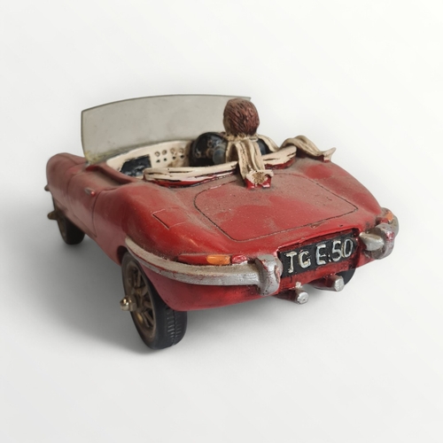 277 - Model Jaguar E-Type motorcar with hipster driver, 45cm long. Shipping group (A).