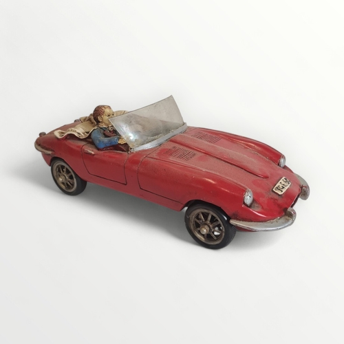 277 - Model Jaguar E-Type motorcar with hipster driver, 45cm long. Shipping group (A).