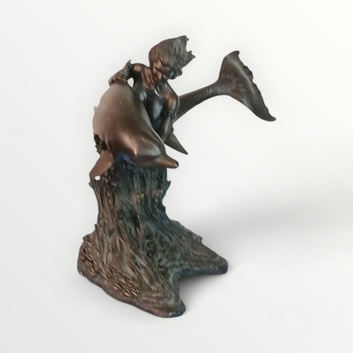 289 - Cast figure of a mermaid with a dolphin on a rocky base, 31cm high. Shipping group (A).